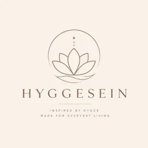 Minimal beige lotus logo for Hyggesein, a Scandinavian-inspired hygge lifestyle and home decor brand with elegant serif typography.